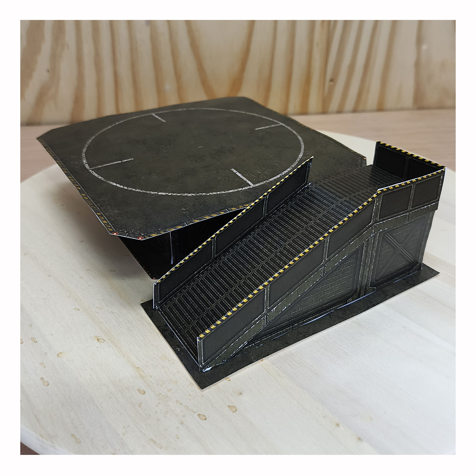 Completed miniature military-style helicopter landing pad with the raised platform and access ramp shown in a detailed 3D view