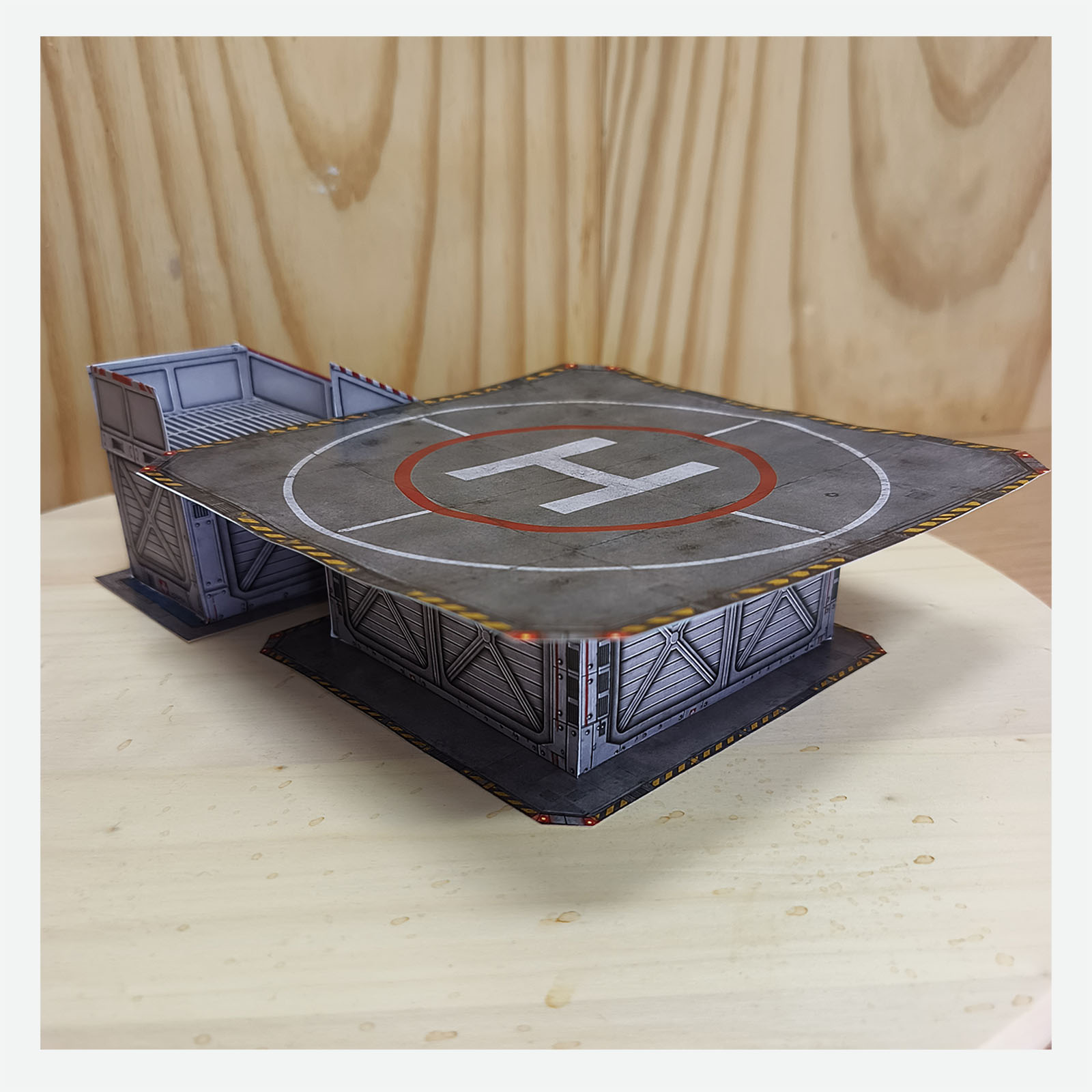 Completed papercraft hospital helipad diorama with access ramp viewed from the side