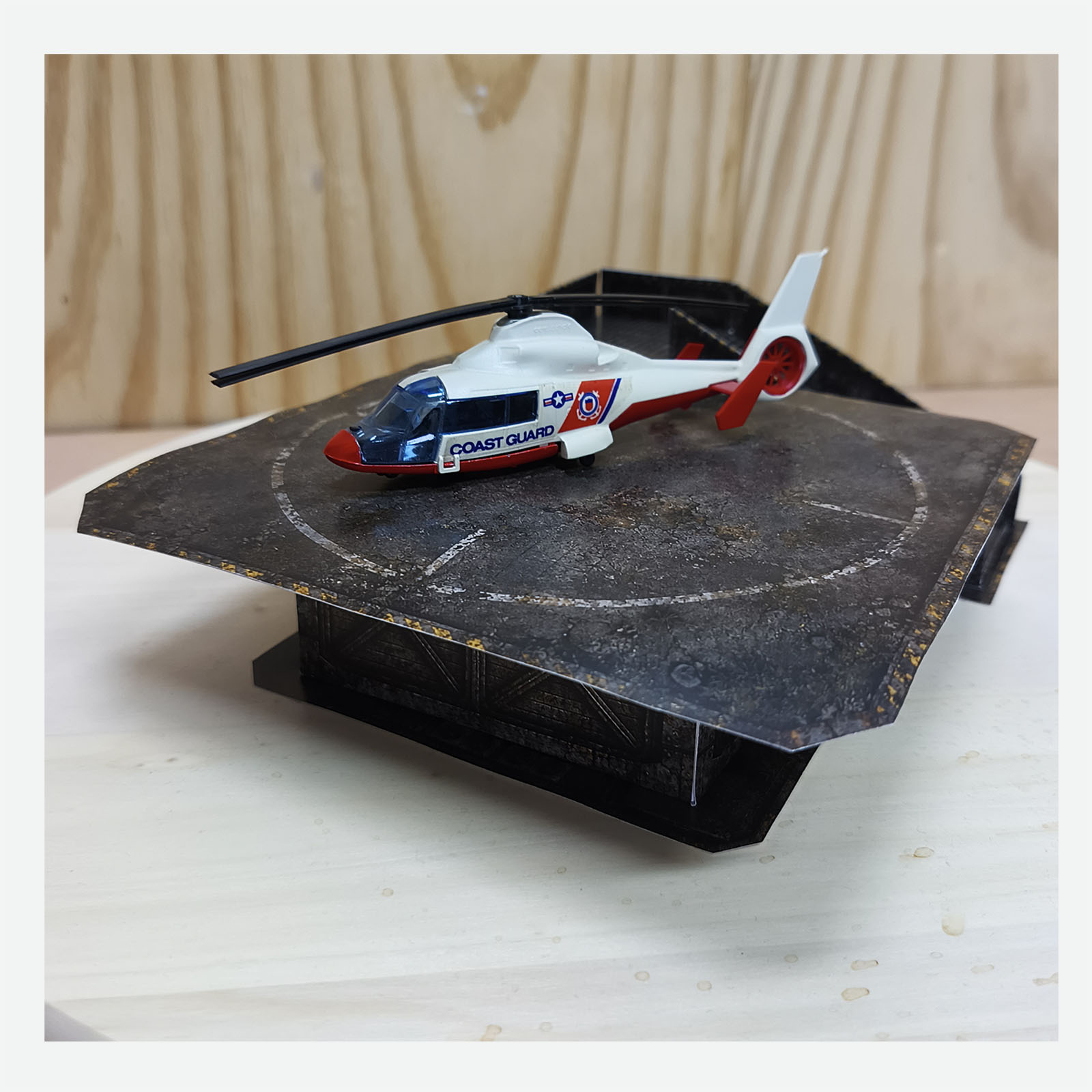 Close view of the completed post-apocalyptic helicopter display base with a Coast Guard helicopter and access ramp positioned behind the platform